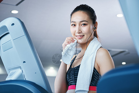 微笑健身房跑步机的女人图片