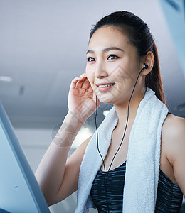 青年女马尾健身房跑步机的女人图片