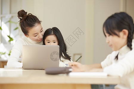 母亲与孩子一起在客厅学习图片