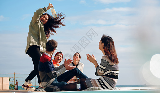 海岸边聚会派对的青年男女喝酒图片