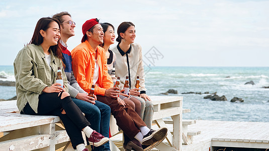 大海游客休假户外酒男人和女人在海边享受聚会背景