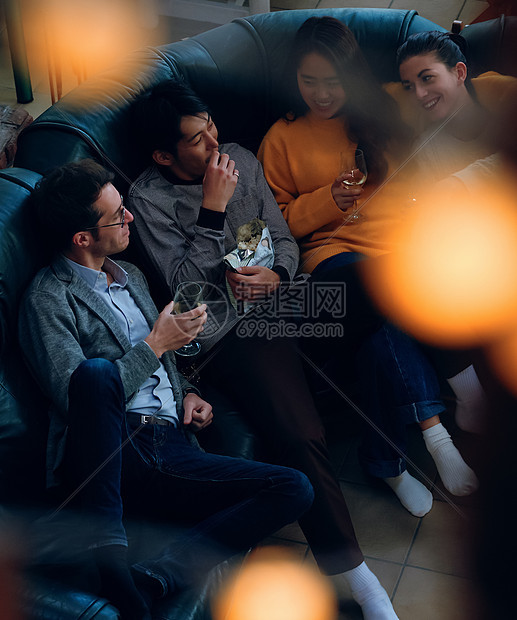 年轻人坐在沙发上一起喝酒聊天图片