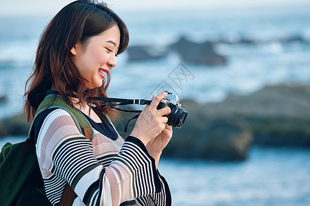 女人独自在海边旅行拍照图片