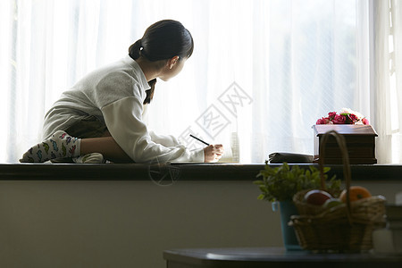 坐在窗台看书学习的小女孩图片
