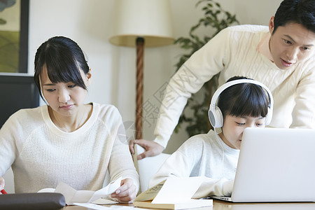 用笔记本电脑的女孩和父母一起学习图片