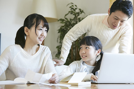 用笔记本电脑的女孩和父母一起学习图片