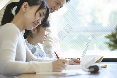 用笔记本电脑的女孩和父母一起学习图片