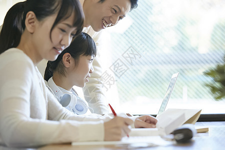 用笔记本电脑的女孩和父母一起学习图片