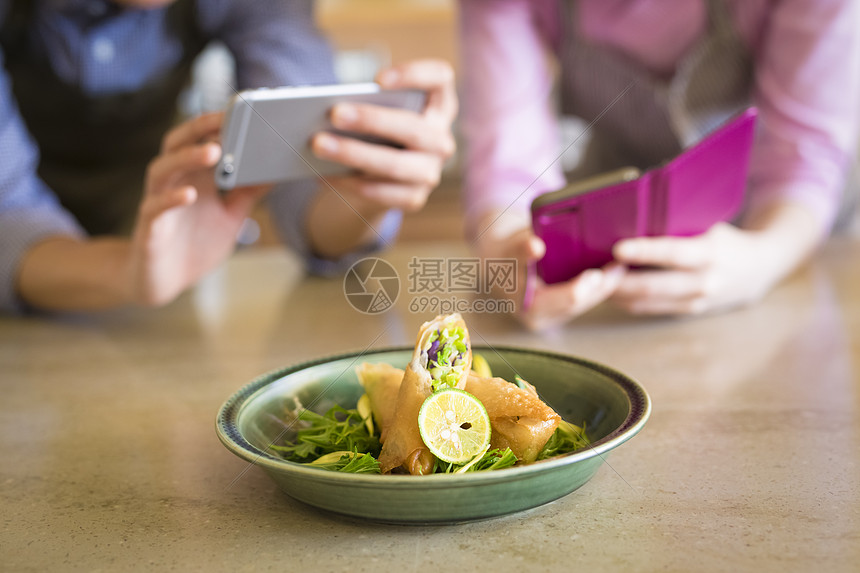 男子在厨房用手机拍拌凉菜图片