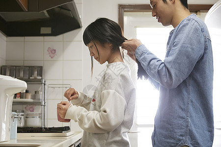 单身父亲给女儿扎辫子准备早餐图片