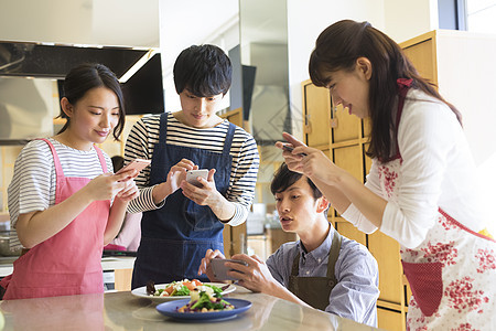 烹饪课拍摄食物的年轻男女图片