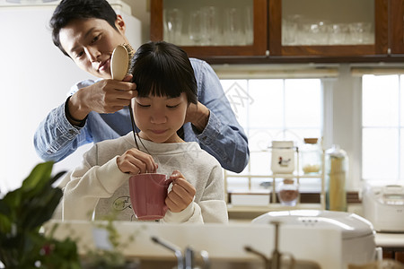 单亲父亲为女儿早晨梳头发图片素材