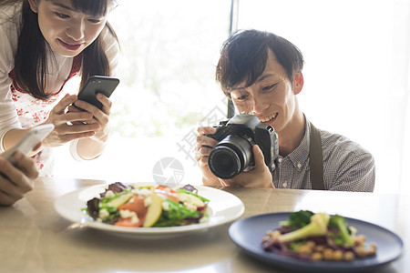 笑脸微笑青年拍摄食物的男女图片