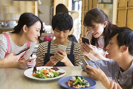 5个人天围裙拍摄食物的男女图片