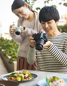 起居室日本人约会拍摄食物的男女图片