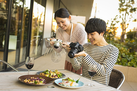 年轻男女手机拍摄美食图片