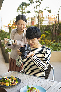 饮食男子露天咖啡馆拍摄食物的男女图片