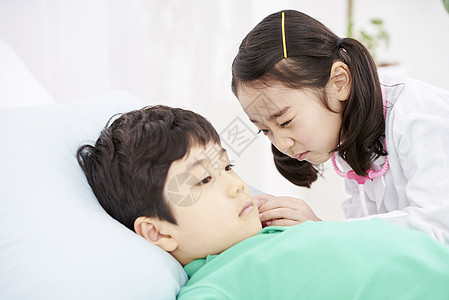 角色扮演医生的小女孩为男孩检查身体图片