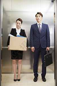 公司职员抱纸箱进电梯图片