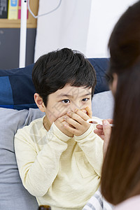 妈妈照顾生病的小男孩吃药图片