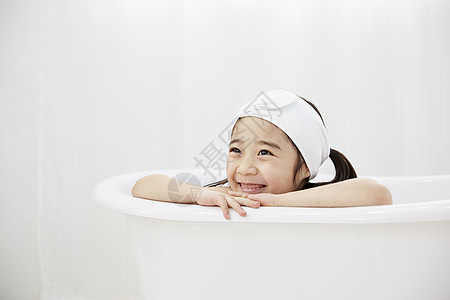 小女孩趴在浴缸边缘图片