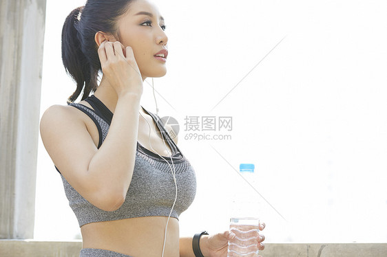 穿着运动服带着耳机的年轻女子图片