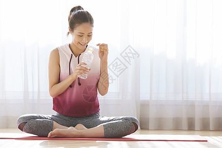 拿着水瓶微笑的成年女子图片