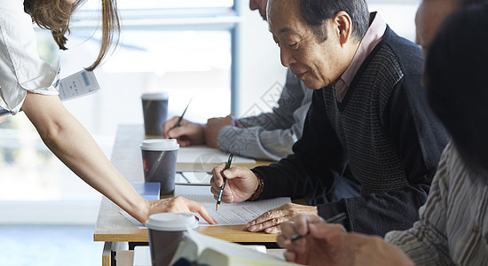 指点亚洲人土著的高级人员参加英语会话课图片