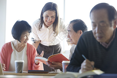 70多岁女生课本高级人员参加英语会话课图片