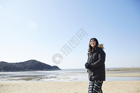 海滩上散步的年轻女子图片