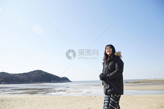 海滩上散步的年轻女子图片