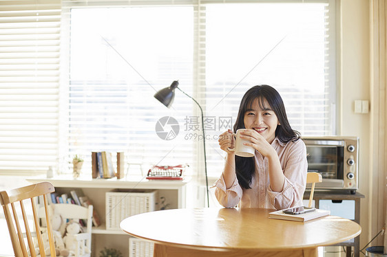 拿着咖啡杯开心微笑的青春少女图片
