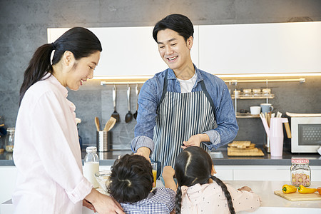 在家庭厨房里做饭的一家人图片