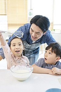 在厨房里跟父母一起做甜品的小朋友图片