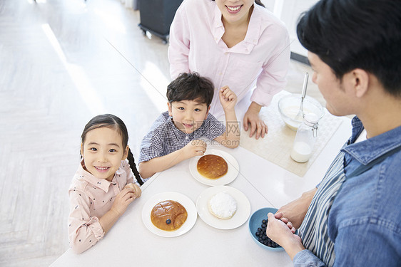 在厨房里跟父母一起做甜品的小朋友图片