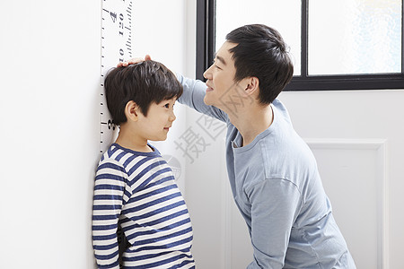 刻度测量儿子身高的爸爸背景