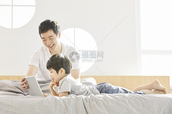 看着平板电脑开心的父子俩图片