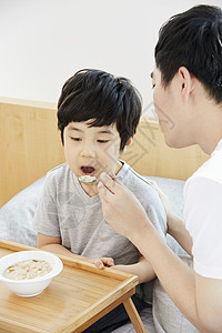 父亲拿着勺子喂儿子吃饭图片