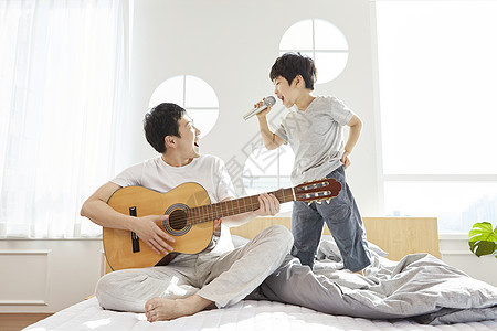 卧室里拿着吉他话筒的父子俩图片