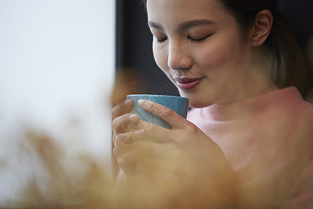 捧着水杯的青年女性图片