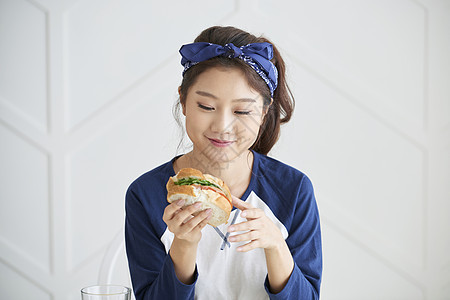 吃三明治愉快的年轻女人图片