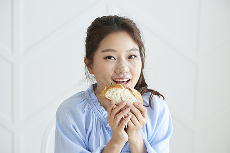 吃三明治愉快的年轻女人图片
