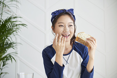 年轻女人开心的吃早餐面包图片