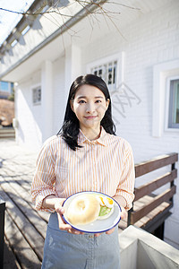 青年户外的年轻女人端着早餐图片