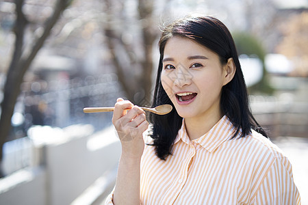 拿着木勺微笑的成年女子图片