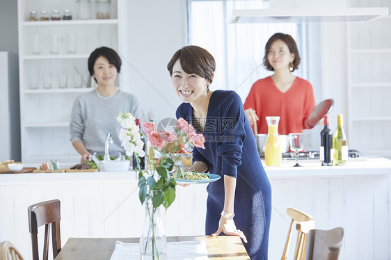 微笑女人们在厨房做午餐图片