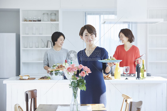 女人在餐桌上上菜图片