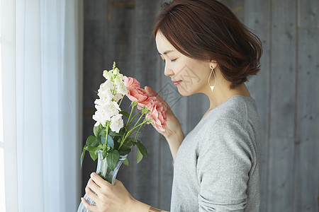 嗅闻鲜花香气的短发女子图片