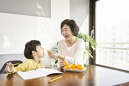 奶奶喂小男孩吃水果图片
