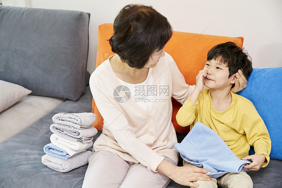 小男孩和奶奶在客厅叠衣服图片